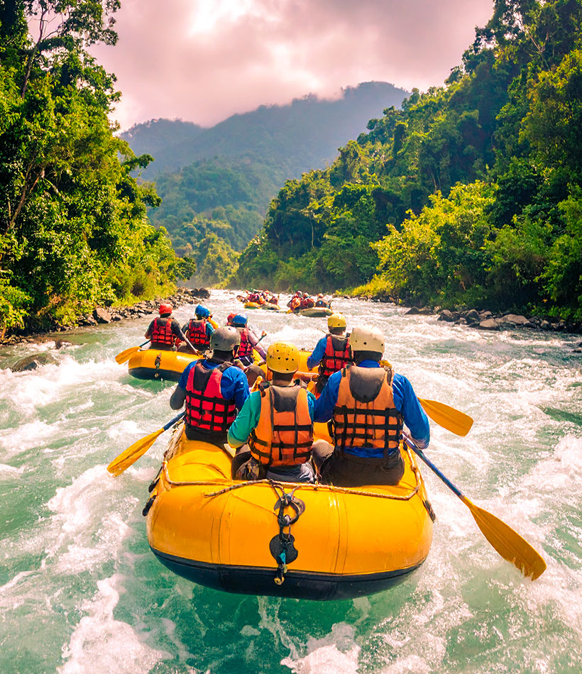 Boote mit Touristen beim River Rafting auf Bali.